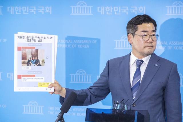 더불어민주당 당 대표 후보에 출마한 박찬대 의원이 27일 국회 기자회견 뒤 가진 취재진과 인터뷰에서 제보로 입수한 지귀연 판사의 의혹 관련 자료를 공개하고 있다. 연합뉴스