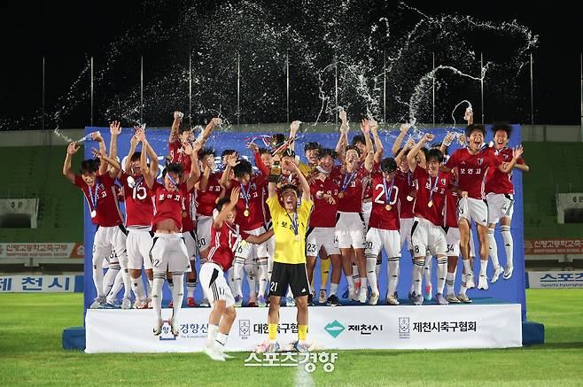 충북 제천종합운동장에서 26일 열린 58회 대통령금배 전국고교축구대회 유스(U-17) 결승전에서 서울 보인고가 충남 신평고를 꺾은 뒤 시상대에 올라 우승컵을 들고 환호하고 있다. 제천|권도현 기자