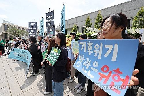 소년기후소송, 시민기후소송, 아기기후소송, 탄소중립기본계획소송 관계자들이 작년 4월 23일 오후 서울 종로구 헌법재판소 앞에서 열린 기후 헌법소원 첫 공개변론 공동 기자회견에서 정부의 기후 위기 대응 부실을 규탄하고 있다. [연합뉴스 자료사진]