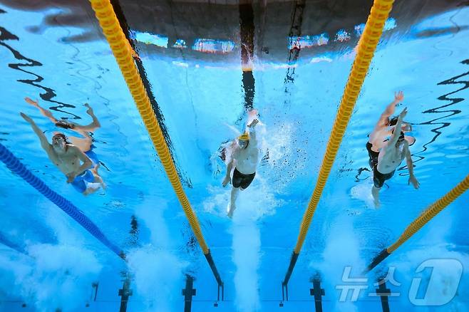 김우민(왼쪽)이 27일 열린 2025 싱가포르 세계수영선수권대회 남자 자유형 400m 결선에서 새무얼 쇼트, 루카스 메르텐스와 역영하고 있다. ⓒ AFP=뉴스1