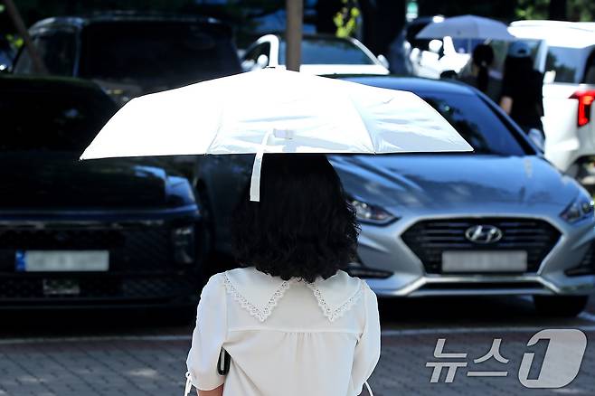 폭염이 이어진 28일 오전 대구 달서구청 민원실에서 한 시민이 '양심양산'을 빌려 뙤약볕을 가린 채 청사를 나서고 있다. 2025.7.28/뉴스1 ⓒ News1 공정식 기자