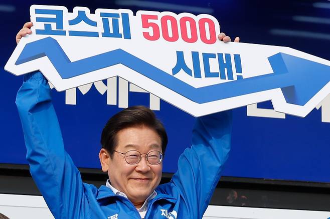 이재명 대통령이 후보 시절  '코스피 5000시대'라고 적힌 피켓을 들고 있다./뉴스1