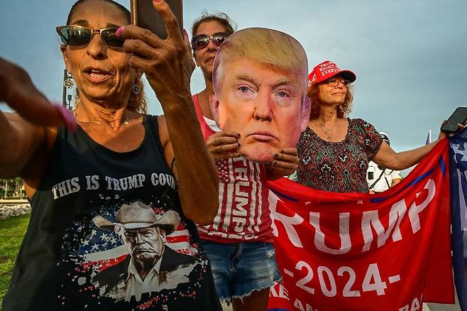2025년 7월17일 미국 플로리다주 웨스트팜비치에서 도널드 트럼프 대통령 지지자들이 트럼프의 얼굴을 형상화한 조형물과 펼침막을 들고 집회하고 있다. AFP 연합뉴스