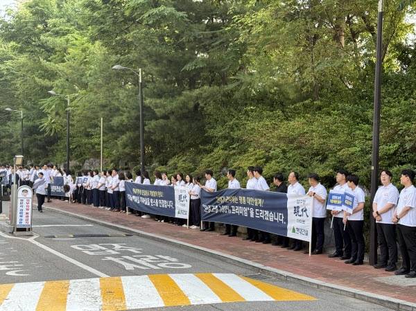 현대건설 직원들이 지난 6월 압구정2구역에 모여 출근길 조합원들에게 인사하고 있다. 부동산 커뮤니티 사진 갈무리