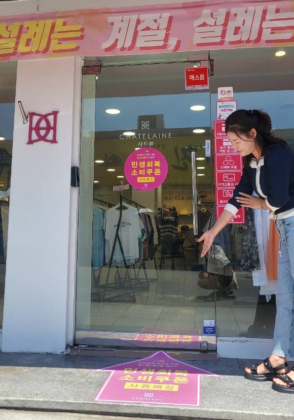 패션그룹형지 샤트렌 점주가 민생회복 소비쿠폰 사용처임을 알리고 있다. [사진=패션그룹형지]