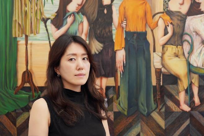 안소희 작가가 대상 수상작 ‘우리를 위한 연주’를 배경으로, 화면을 응시하고 있다.