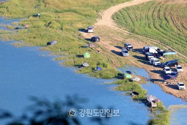 ▲ 지난 27일 폭염 속에 인제군 인제대교 아래에 위치한 소양호 변에서 낚시꾼들이 붕어낚시 삼매경에 빠져 있다.