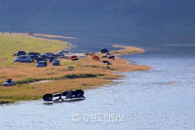 ▲ 지난 27일 폭염 속에 인제군 인제대교 아래에 위치한 소양호 변에서 낚시꾼들이 붕어낚시 삼매경에 빠져 있다.