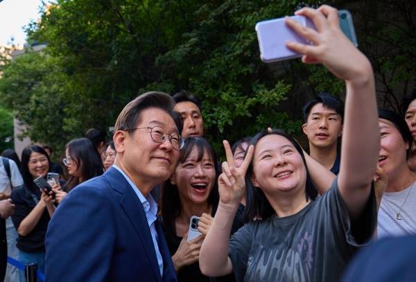 ▲2025년 7월 이재명 대통령이 서울 종로구 식당에서 직원들과의 퇴근길 외식을 위해 이동하던 중 만난 시민들과 사진을 찍고 있다. 사진=대통령실