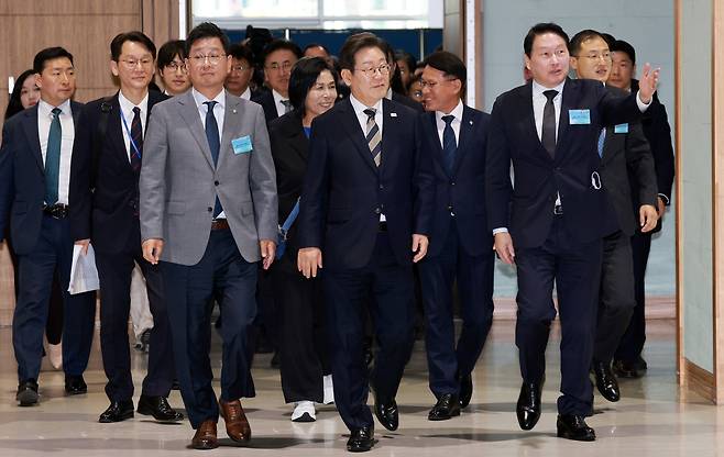 이재명 대통령이 지난달 20일 울산전시컨벤션센터에서 열린 울산 인공지능(AI) 데이터센터 출범식에 참석해 최태원  SK그룹 회장의 안내를 받고 있다. 이 대통령은 취임 이후 울산, 광주, 대전, 부산 등 광폭 지방 행보를 하고 있다.  [연합]