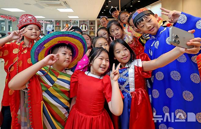 [대구=뉴시스] 이무열 기자 = 28일 대구 북구 대구세계시민교육센터에서 열린 여름방학 세계문화체험학습에서 각국 전통의상을 차려입은 초등학생들이 기념촬영을 하고 있다. 2025.07.28. lmy@newsis.com
