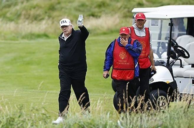 턴베리 골프클럽에서 골프를 치다 사람들에게 손을 흔드는 트럼프 대통령. 연합뉴스
