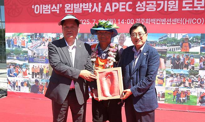 28일 경주화백컨벤션센터 행사장에서 이범식(가운데) 박사가 왼발 완주 기념 풋프린팅 상패를 전달받고 주낙영 경주시장, 이동협 경주시의회 의장과 함께 기념촬영을 하고 있다.