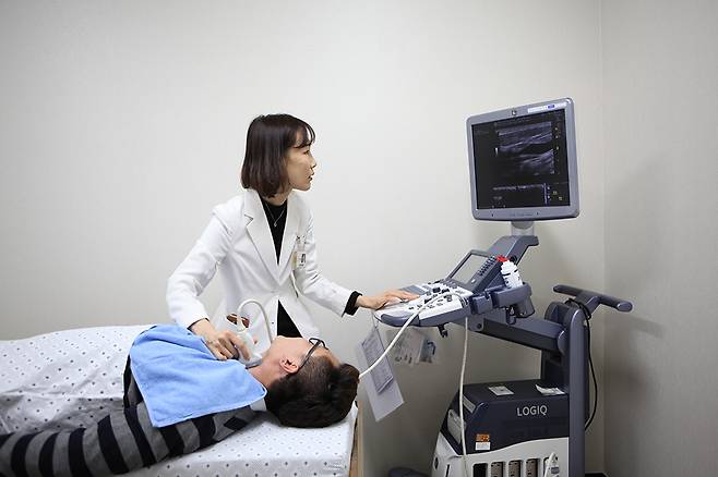 김진화 조선대병원 내분비대사내과 교수가 체중 감소와 피로감 등의 증상으로 내원한 환자에게 갑상선 초음파를 시행하고 있다.<조선대학교병원 제공>
