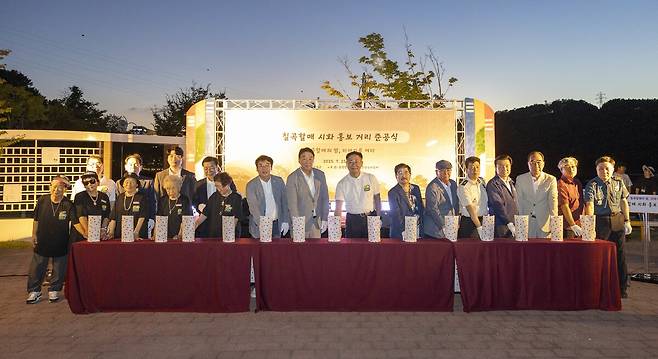 김재욱 칠곡군수(왼쪽 여덟번째)와 정희용 국회의원(왼쪽 일곱번째), 이상승 군의장 등 관계자들이 ‘칠곡할매 시화 홍보거리 조성사업’ 준공식 퍼포먼스를 하고 있다. /칠곡군 제공