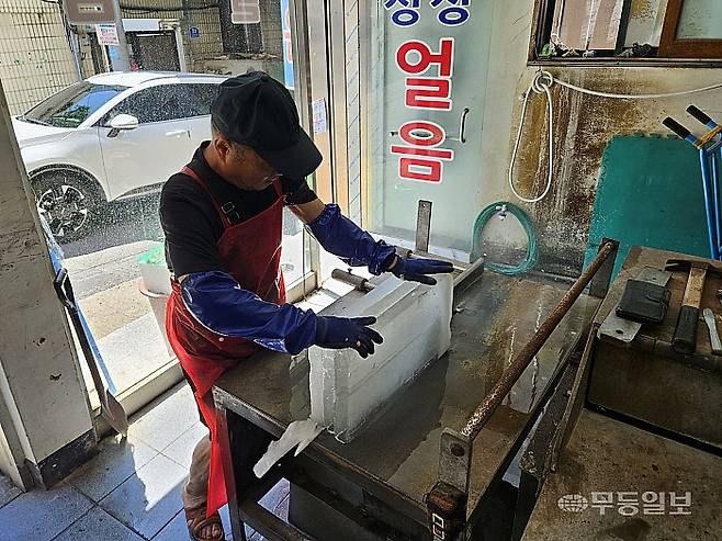 28일 광주 북구 말바우시장 인근에서 얼음가게를 운영중인 정진갑씨가 얼음을 자르고 있다. 강주비 기자