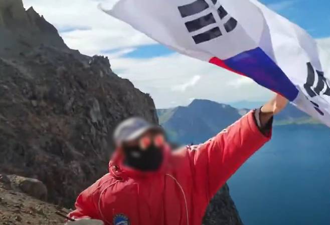 한 유튜버가 백두산 천지에서 태극기를 흔들자 이를 빼앗는 현지 관계자./유튜브 '시수기릿'