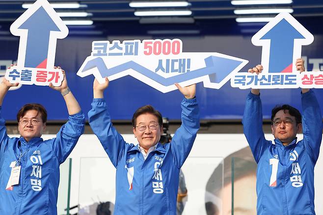 지난 5월29일 이재명 당시 더불어민주당 대선 후보가 서울 서초구 고속버스터미널 유세에서 ‘코스피 5000 시대!’라고 쓰인 팻말을 들어 보이며 경제 회복 퍼포먼스를 하고 있다. 연합뉴스