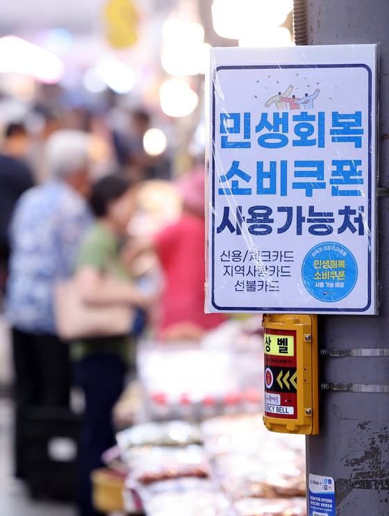 지난 27일 서울 동대문구 청량리종합시장의 한 점포에 소비쿠폰 사용 가능 안내문이 붙어 있다. 뉴스1