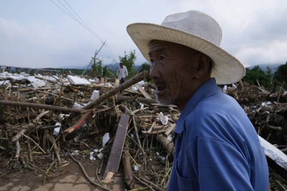 28일 극한호우가 강타한 베이징 교외 미윈현의 한 남성이 홍수에 폐허가 된 마을을 지켜보고 있다. AP=연합뉴스