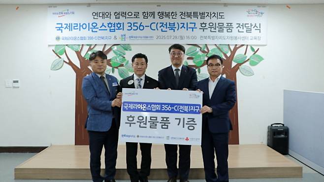 박성춘 국제라이온스협회 356-C(전북)지구 총재가 28일 전북도자원봉사센터에서 후원물품 등을 전달한 뒤 관계자들과 함께 기념촬영을 하고있다./사진=전북도