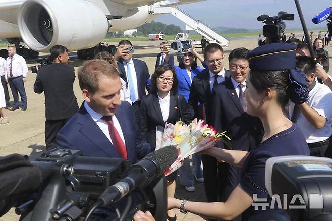 [평양=AP/뉴시스] 알렉산드르 코즐로프 러시아 천연자원부 장관이 대표단을 이끌고 28일 북한 평양국제공항에 도착해 북한 승무원으로부터 꽃다발을 받고 있다. 러시아 대표단은 모스크바와 평양을 연결하는 첫 직항 여객기 편으로 평양에 도착했다. 2025.07.29.
