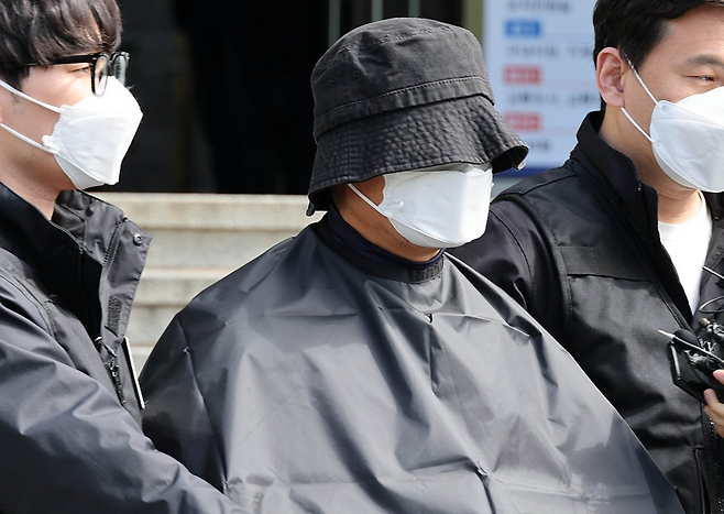 부산 법원 앞에서 생방송하던 유튜버를 살해한 혐의(특가법상 보복살인)를 받는 50대 유튜버가 지난해 5월16일 부산 연제경찰서에서 검찰 송치를 위해 이동하고 있다. ⓒ연합뉴스