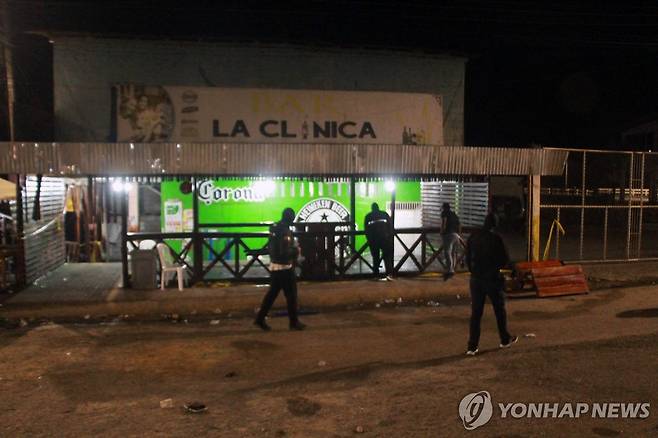 28일(현지시간) 에콰도르 총격 사건 현장 살피는 경찰 [엘엠팔메 AFP=연합뉴스. 재판매 및 DB 금지]