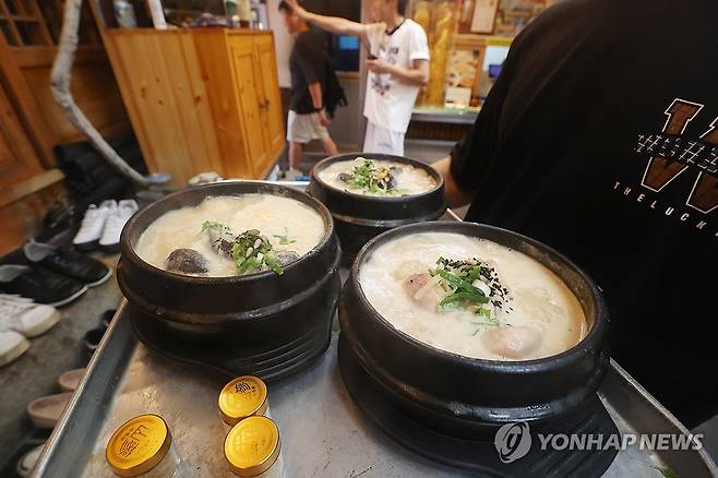 중복 앞둔 삼계탕집 (서울=연합뉴스) 진연수 기자 = 중복을 하루 앞둔 29일 서울 시내의 한 삼계탕집에서 직원이 삼계탕을 서빙하고 있다. 2025.7.29 jin90@yna.co.kr