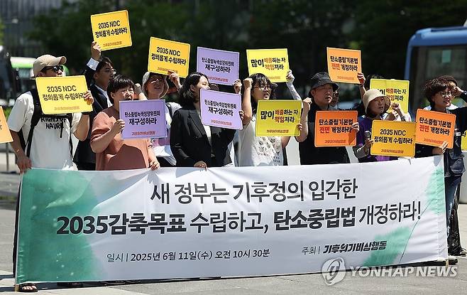 탄소중립법 개정 촉구 기자회견 (서울=연합뉴스) 김성민 기자 = 기후위기비상행동이 11일 서울 종로구 광화문광장에서 연 '2035 감축목표 수립 및 탄소중립법 개정 촉구 기자회견'에서 참가자들이 손팻말을 들고 있다. 2025.6.11 ksm7976@yna.co.kr