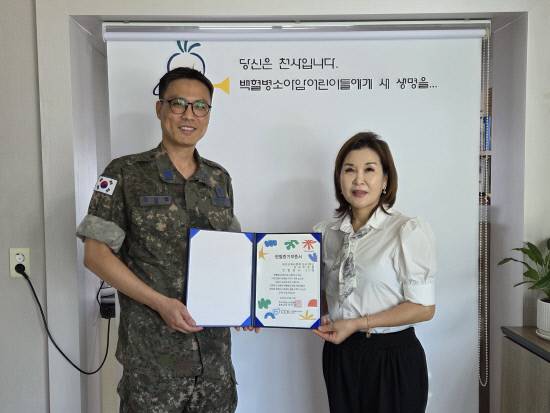 공군교육사령부 예하 군수1학교 이상필 상사(왼쪽)가 가족들과 함께 모은 헌혈증을 한국백혈병소아암협회에 기부하고 있다.