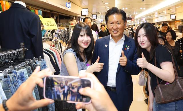 더불어민주당 대표 선거에 출마한 정청래 의원이 30일 인천 부평구 부평역지하상가에서 시민들과 기념 촬영하고 있다. [연합뉴스]