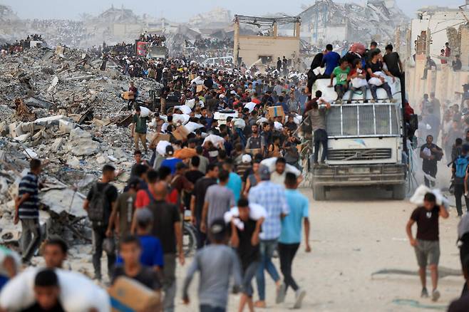 29일(현지시각) 가자 북부 베이트라히아에 도착한 구호 트럭에서 주민들이 식량 등을 옮기고 있다. 베이트라히아/로이터 연합뉴스