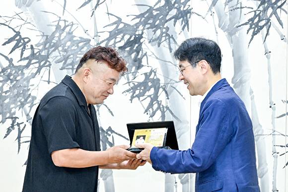 김정기 조직위원장이 황영조 감독에게 홍보대사 위촉패를 전달하고 있다 [사진=대구시]
