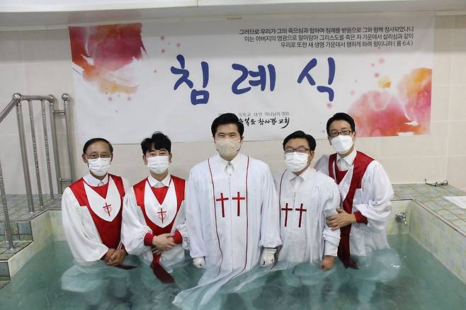 전주순복음참사랑교회 남기곤(가운데) 목사가 지난해 침례식에서 집례자들과 함께 침례탕에서 기념사진을 촬영하고 있다.  전주 순복음참사랑교회 제공