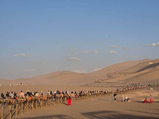 중국 간쑤성 둔황의 명사산 월아천에서 낙타체험을 하는 모습.