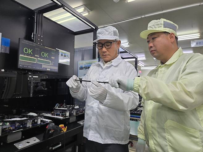 조호준 엑사옵토닉스 대표이사(왼쪽)와 권오창 삼성전자 ESG&스마트공장지원센터 위원이 발광다이오드(LED) 조명 검사기 앞에서 검사 대기 LED 기판을 살펴보고 있다. 삼성전자
