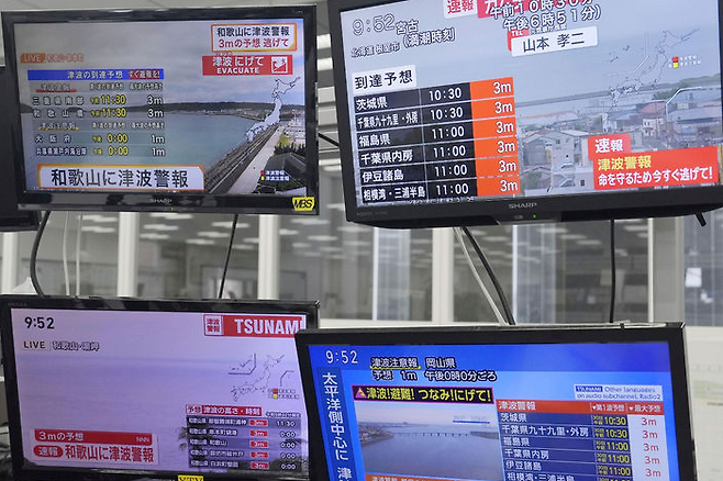30일(현지 시간) 러시아 캄차카반도 인근 해상에서 강진이 발생해 일본 일부 지역에 쓰나미 경보가 발령된 가운데 오사카의 TV에서 쓰나미 경보 속보를 전하고 있다.[뉴시스]