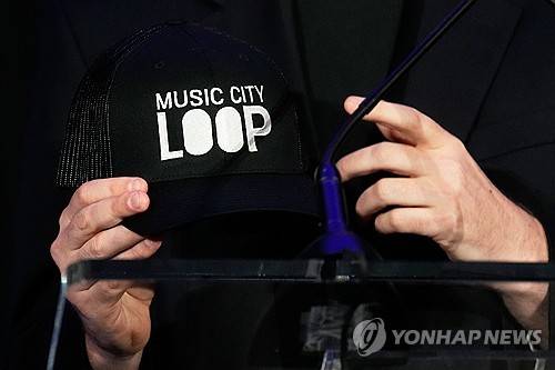 보링컴퍼니 CEO가 지난 28일 행사에서 '뮤직 시티 루프'라는 글자가 인쇄된 모자를 들고 있는 모습. [AP=연합뉴스. 재판매 및 DB 금지]