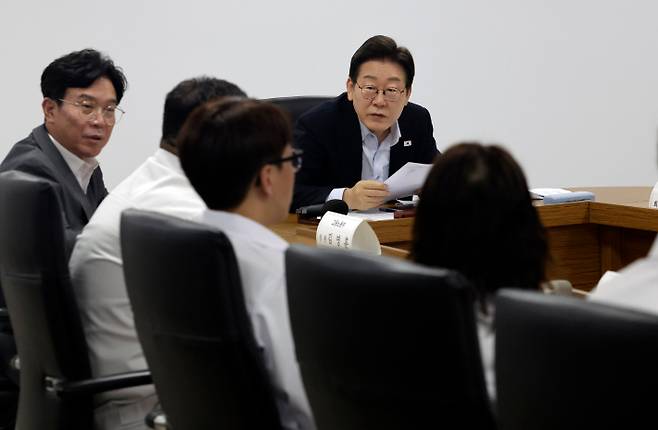 이재명 대통령이 25일 경기 시흥시 SPC 삼립 시화공장에서 열린 산업재해 근절 현장 노사간담회에서 SPC 삼립 직원의 발언을 듣고 있다. 이 대통령 왼쪽은 김영훈 고용노동부 장관. 연합뉴스