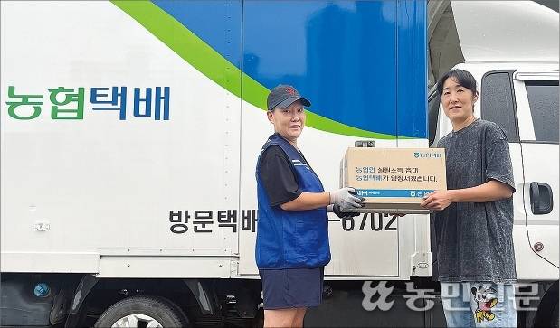 김지현씨(오른쪽)가 도시 소비자에게 보내는 농산물 상자를 농협택배 운송기사 최지연씨에게 전달하고 있다.