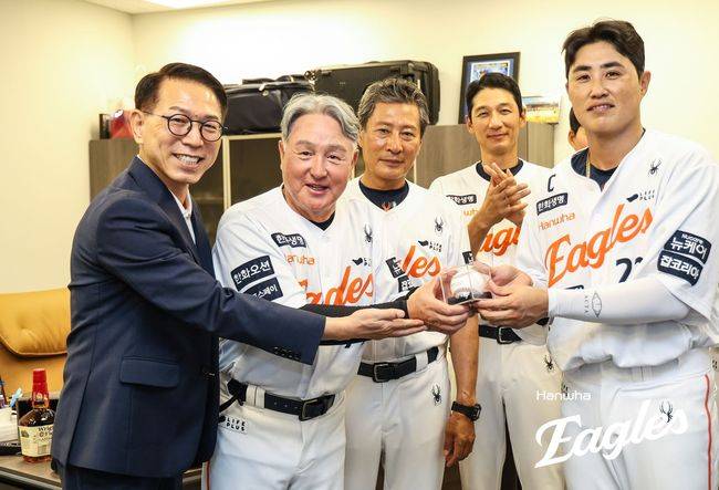 한화 김경문 감독이 이글스 부임 100승 기념구를 받고 포즈를 취하고 있다. 왼쪽부터 박종태 대표이사, 김경문 감독, 양승관 수석코치, 추승우 외야주루코치, 주장 채은성. /한화 이글스 제공