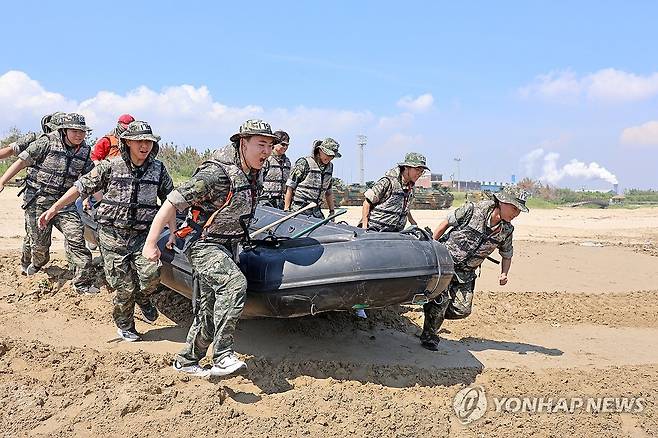바다로 돌진 (포항=연합뉴스) 손대성 기자 = 30일 경북 포항시 남구 도구해수욕장 일원에서 열린 여름 해병대 캠프에서 참가자들이 IBS(소형고무보트)를 타는 체험을 하기 위해 보트를 들고 해변으로 가고 있다. 2025.7.30 sds123@yna.co.kr