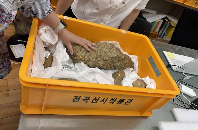 연천군 관계자가 2021년 연천군 전곡리유적 인근에서 출토된 '초대형 주먹도끼'의 상태를 확인하고 있다. 사진=연천군청