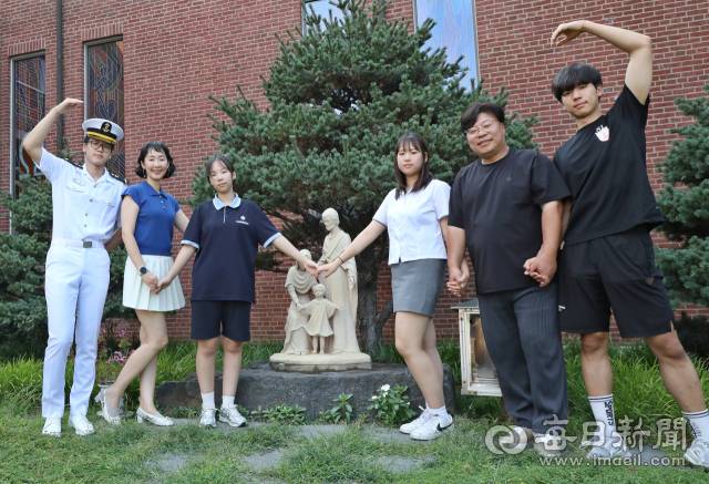 엄마 유미원씨가 근무하는 동촌성당 성가정상 앞에서 여섯 가족이 손을 맞잡고 있다. (왼쪽부터)첫째 유비, 유미원 씨, 넷째 유온, 셋째 유주, 아빠 조광형 씨, 둘째 유신. 정운철 기자 woon@imaeil.com