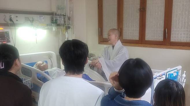 능행 이사장이 환자 가족들이 둘러앉은 가운데, 말기 암환자의 마지막 가는 길을 살피고 있다. [사진=정토마을 자재병원]