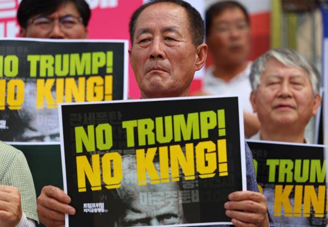 31일 서울 주한 미국대사관 인근에서 농민의길과 트럼프위협저지공동행동 등 단체가 주최한 집회에 참가한 시민이 국내 농산물 시장 개방을 요구한 미국 트럼프 행정부를 규탄하는 피켓을 들고 있다. 연합뉴스