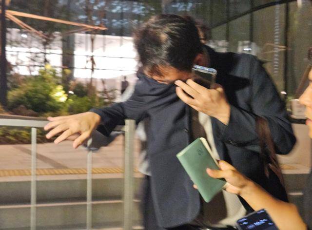 윤석열 전 대통령 부인 김건희 여사의 친오빠인 김진우씨가 28일 김 여사 관련 의혹들을 수사하는 민중기 특별검사팀 조사를 마친 뒤, 옷깃으로 얼굴을 가린 채 취재진을 뿌리치며 특검팀 사무실(서울 종로구 KT광화문빌딩)을 나서고 있다. 연합뉴스