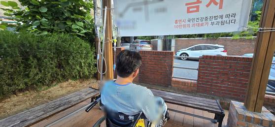 A씨(54)가 지난 27일 휠체어에 탄 채 병원 내 쉼터에서 쉬고 있다. A씨는 "교도소에 면회 온 딸내미에게 '아빠 믿지?' 그랬더니 딸이 '아빠 믿어' 그러는데 눈물이 났다"고 했다. A씨 딸은 아버지 뒤를 이어 경찰을 준비 중이라고 한다. 김준희 기자