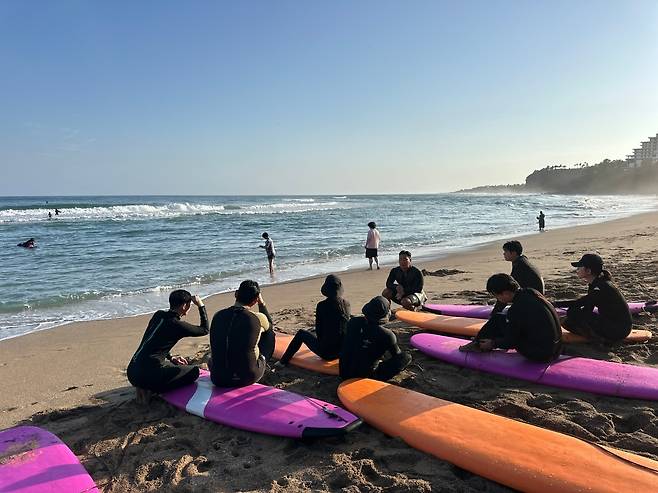 Beginners participate in a surfing lesson at Jungmon Saekdal Beach, Jeju Island (Jungmon Surfing School)